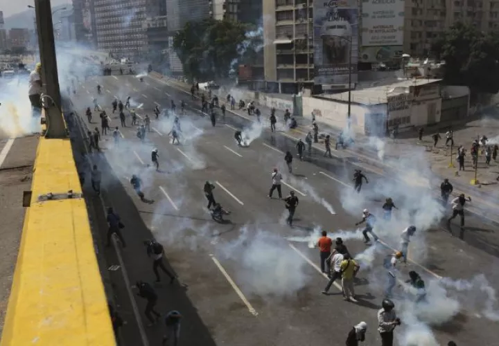 Un grupo de manifestantes se enfrentan a la policía. /Foto AP