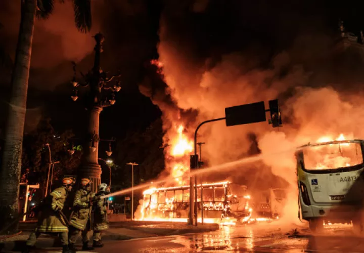 Un grupo de encapuchados incendió varios autobuses. FOTOS/AFP