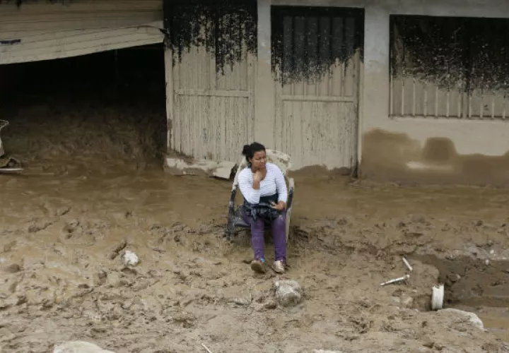 Una mujer observa la destrucción a su alrededor. FOTO/AP