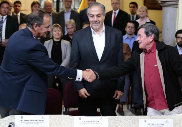 Los jefes negociadores del Gobierno colombiano, Juan Camilo Restrepo (c-i), y del Ejercito de Liberación Nacional (ELN), Pablo Beltrán (c-d), estrechan sus manos. FOTO/EFE