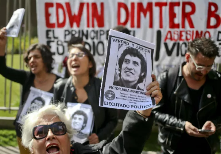Un grupo de personas exigen justicia para Víctor Jara. FOTO/AP