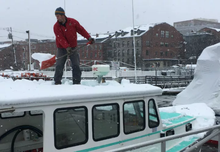 Un hombre quita la nieve del techo de su embarcación. FOTO/AP