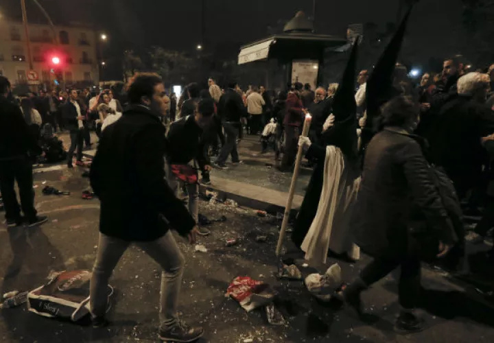 Nazarenos de La Esperanza de Triana visiblemente afectados tras sufrir una estampida. FOTO/EFE
