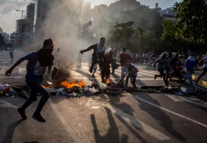 Un grupo de venezolanos se enfrentan con la policía. FOTO/EFE