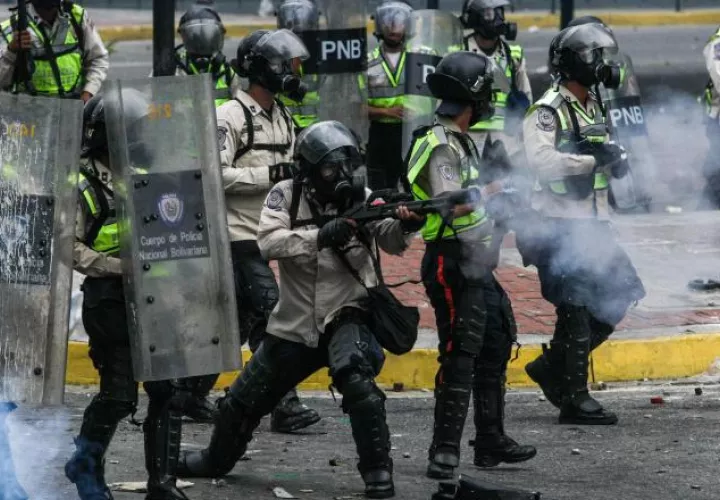 Integrantes de la Policía Nacional Bolivariana (PNB) se enfrentan a manifestantes. /Foto EFE