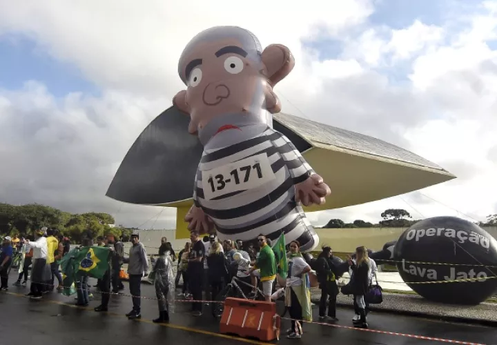 Manifestantes sostienen un globo que representa a Lula vestido de prisionero. /Foto AP