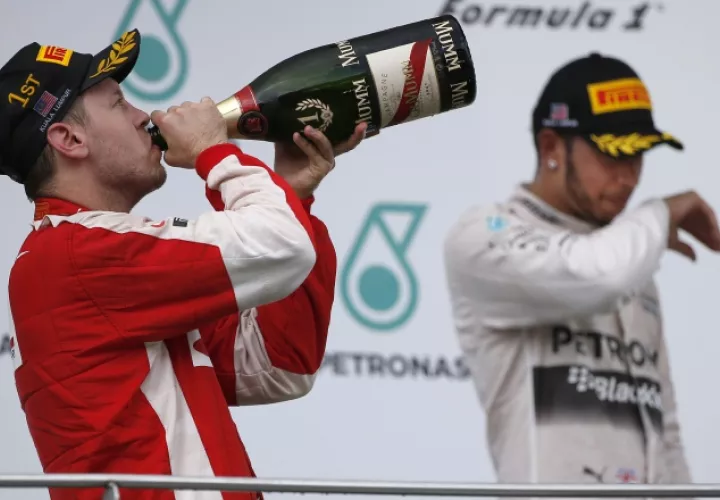 Sebastian Vettel (izq.) celebra un triunfo ante Lewis Hamilton. /Foto AP