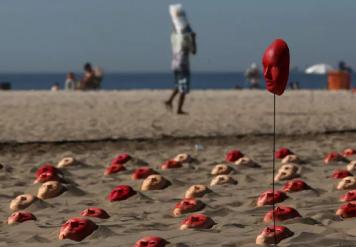 Más de 500 máscaras pintadas de rojo fueron dejadas en la playa Copacabana. FOTO/EFE