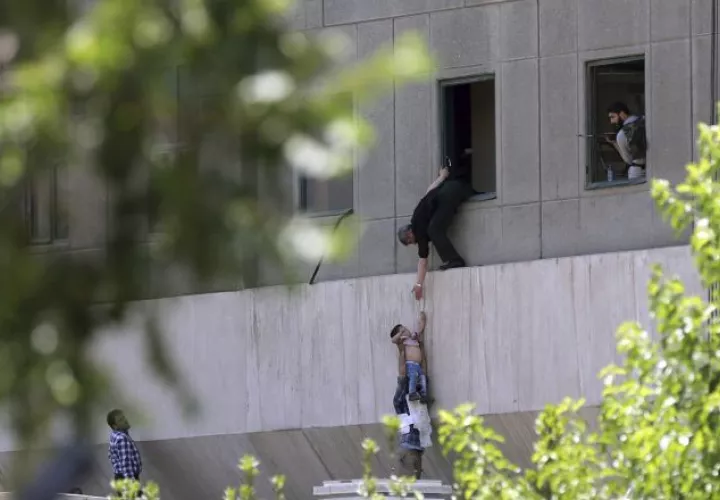 Policías iraníes ayudan a escapar a civiles luego que hombres armados irrumpieran en el Parlamento. /Foto EFE
