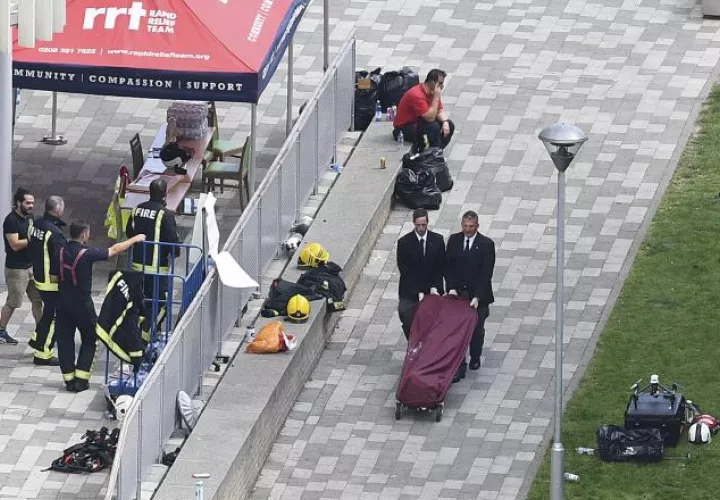 Dos hombres retiran el cuerpo sin vida que falleció en el incendio en la Torre Grenfell en Lancaster. /Foto EFE