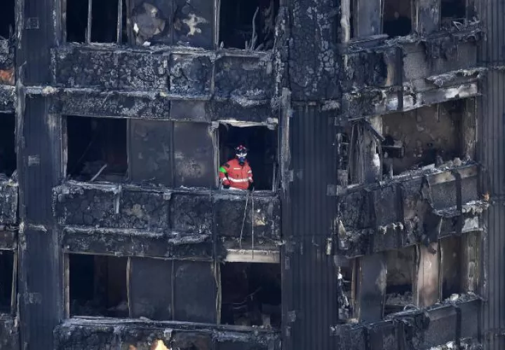 Los bomberos trabajan arduamente en la edificación afectada por el incendio. /Foto AP