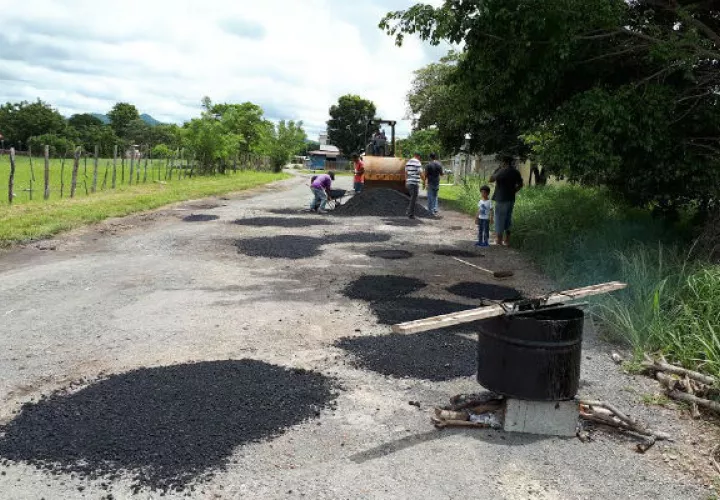 Vecinos tapan los huecos en la vía. Foto: Elena Valdez 