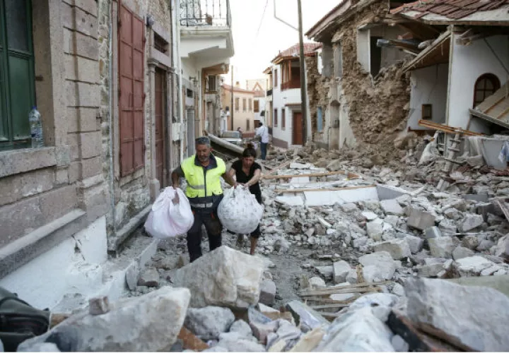 Personas sacan sus pertenencias de los escombros, después de un terremoto de 6,1 grados. FOTO/EFE