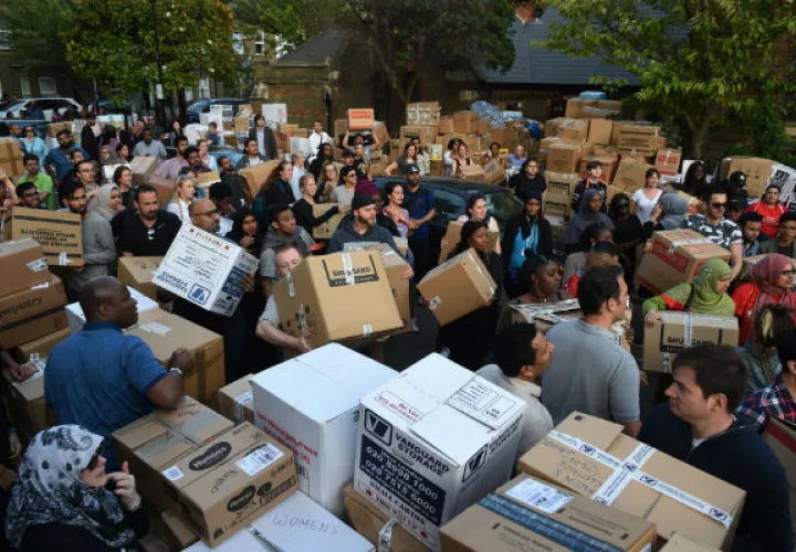Un grupo de personas lleva donaciones a la iglesia St. Clements. Foto/ EFE