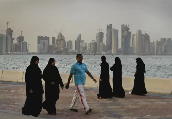Ciudadanos qataríes tras inmensos rascacielos. Foto. AP.