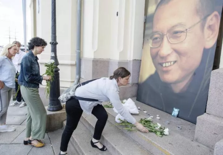 Colocan flores frente a una imagen de Liu Xiabo, fuera del Centro Nobel de la Paz en Oslo, Noruega. /Foto EFE