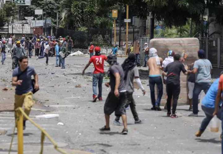 Manifestantes se enfrentan a la Guardia Nacional Bolivariana cerca de la TV estatal VTV en Caracas. EFE