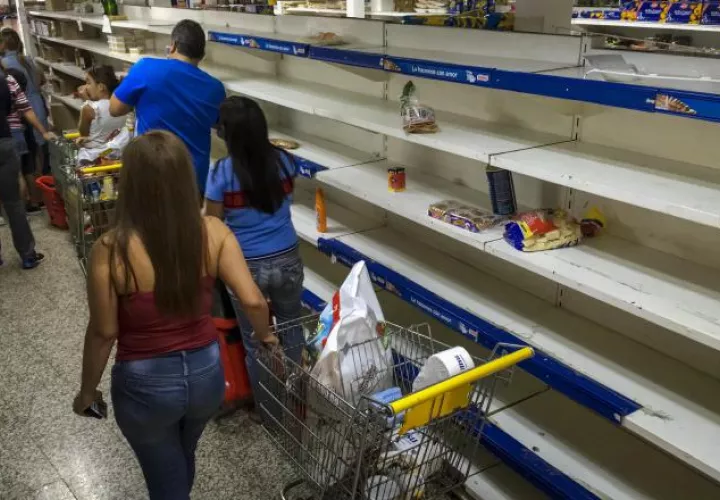 Buscan algún alimento en los supermercados de Caracas. EFE