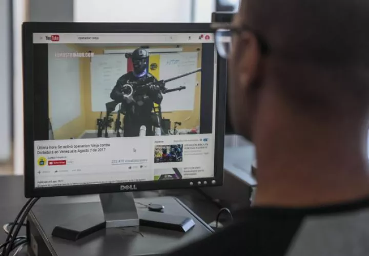 Una persona observa un video de un hombre armado y encapuchado en YouTube en Caracas. /Foto EFE