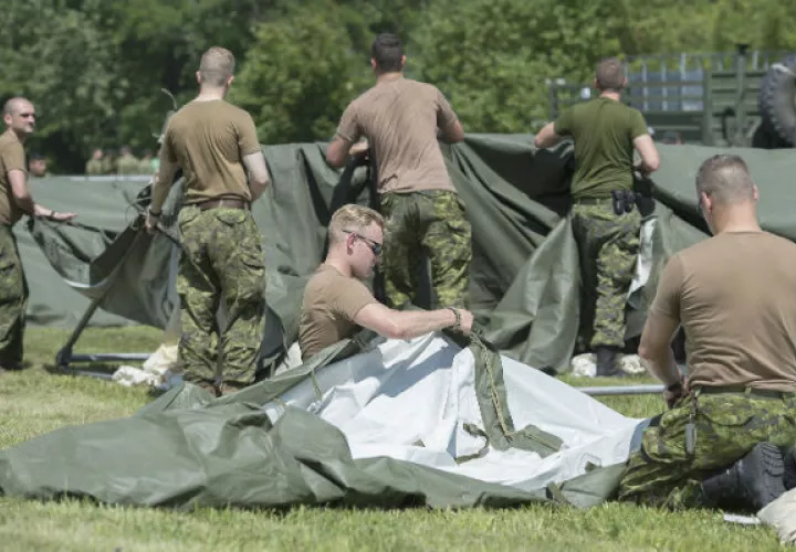 Soldados canadienses levantan toldas. Foto: AP. 