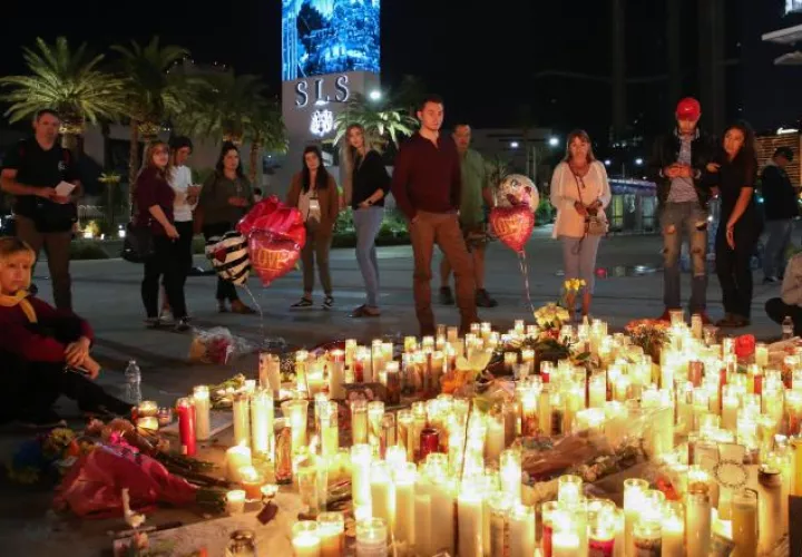 Personas se detienen ante un altar improvisado en memoria a las víctimas del tiroteo ocurrido.  EFE