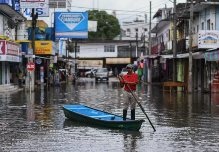 Un hombre se traslada en un bote por las inundaciones causadas por Ramón. Foto: EFE.    