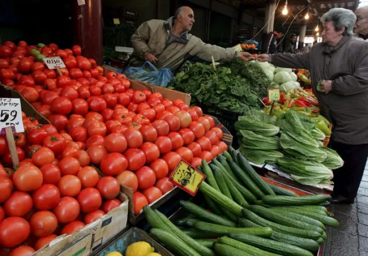 Una mujer compra frutas y verduras en un puesto de verduras y legumbres. EFE