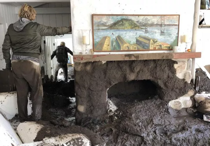 Unas personas tratan de recuperar algunas pertenencias, después de la avalancha de lodo. /Foto EFE