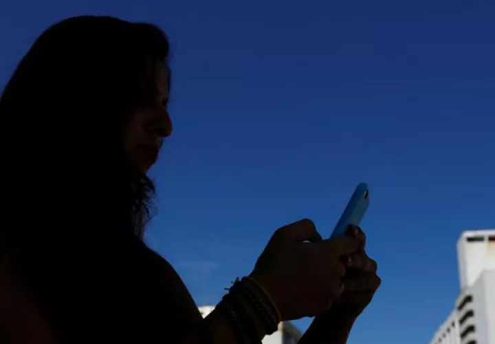 Una mujer mira su teléfono móvil.