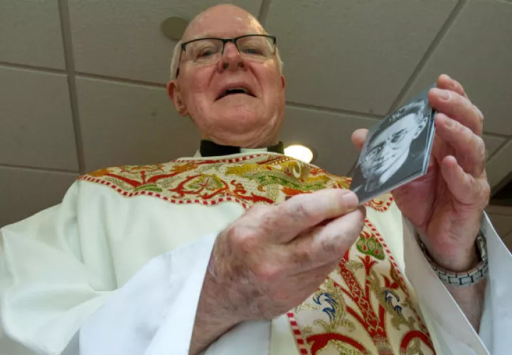 El párroco retirado Michael Driscoll muestra una foto del carmelita holandés Titus Brandsma. FOTO/EFE