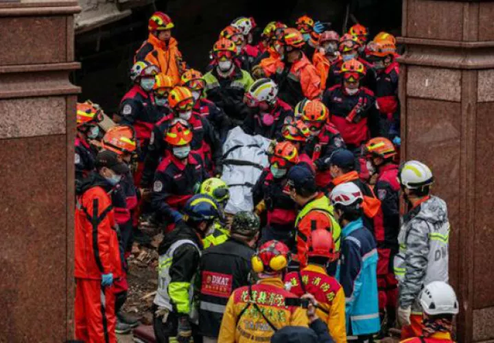 Los equipos de rescate portan un cuerpo tras recuperarlo de un edificio dañado. Foto: EFE 