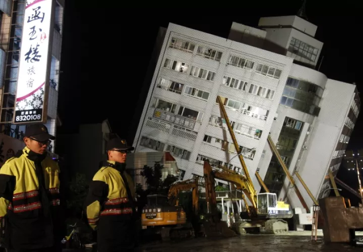 Oficiales vigilan el área donde se llevan a cabo labores de rescate. AP