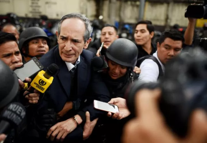 El expresidente de Guatemala Álvaro Colom (c-i) camina escoltado tras ser capturado. EFE