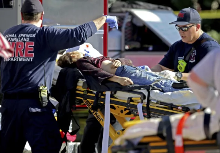 Paramédicos le brindan ayuda a los heridos en el colegio Marjory Stoneman Douglas High School. AP