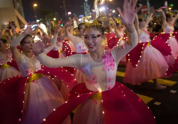 1.  Mujeres disfrazadas danzan durante el desfile.