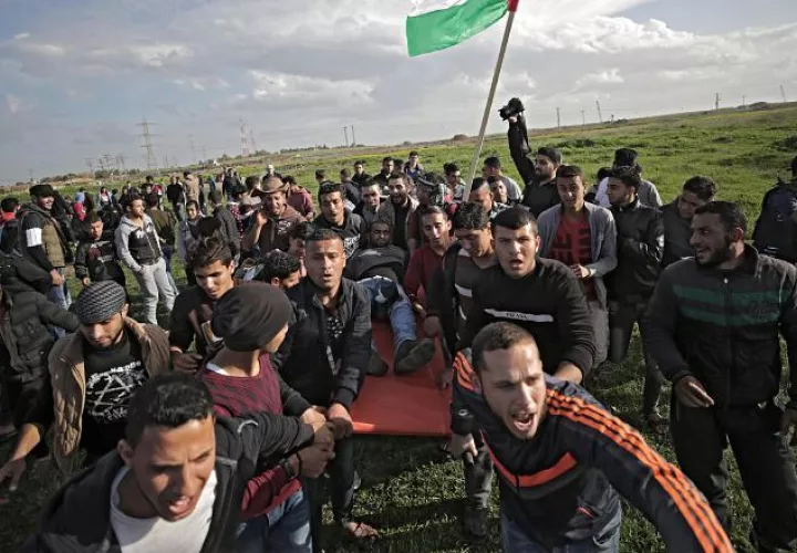 Palestinos desplazan a un herido durante enfrentamientos ayer con tropas israelíes. EFE