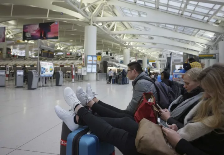 Un grupo de personas se mantienen en la sal de espera del Aeropuerto Internacional JFK. AP