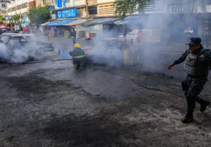 Apagan autos incendiados. EFE