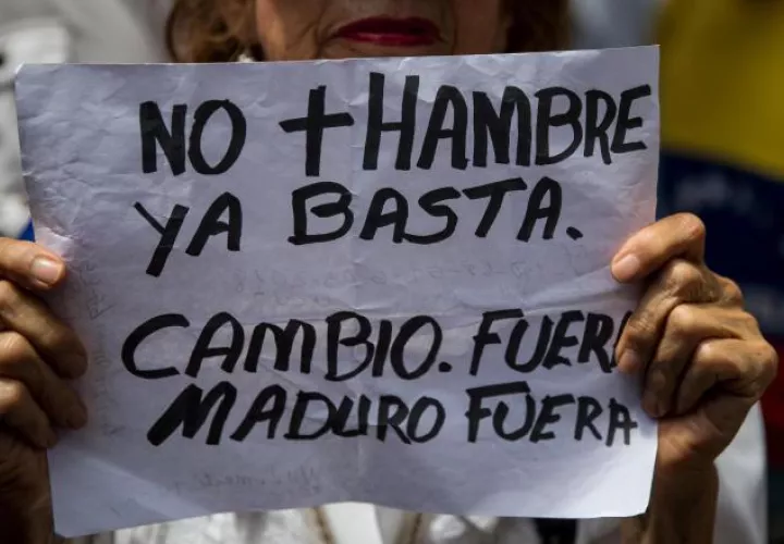Una mujer muestra un cartel durante una de las manifestaciones en contra de las presidenciales. EFE