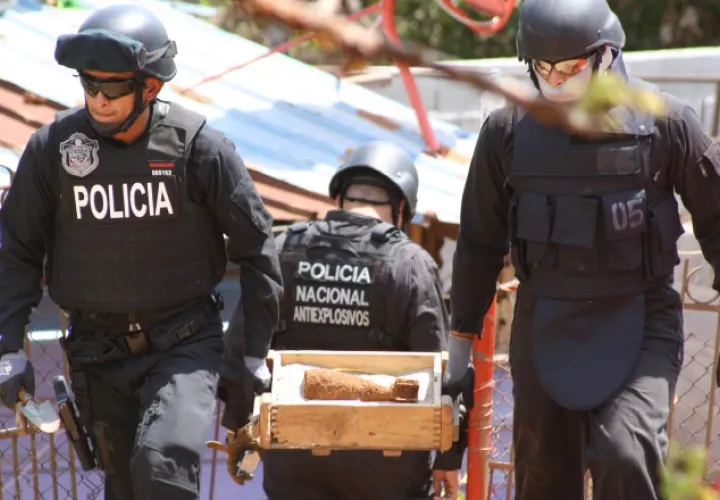 Policías antiexplosivos, al retirar en una caja el mortero de 81 milímetros aún activo, hallado en el patio de una casa en La Chorrera. /Foto Eric A. Montenegro