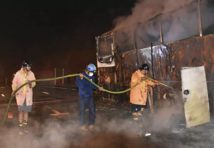 Bomberos apagan el incendio de un bus de dos pisos. FOTO/AP