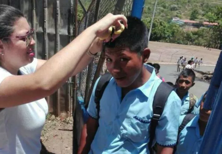 Docente cortando cabello a alumno. Foto: Mayra Madrid. 