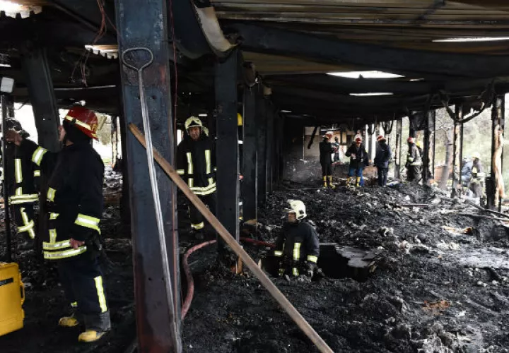 Un equipo de bomberos inspeccionan el escenario. Foto: EFE 