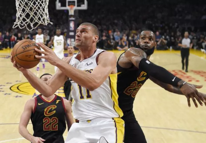 LeBron James (derecha) intentó hacer una tapa a Brook López. Foto AP