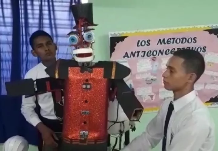 Los estudiantes Sudir Ojo (izq.) y Luis Castillo (der.) muestran el robot construido con piezas hechas con material reciclable. Elena Valdez.