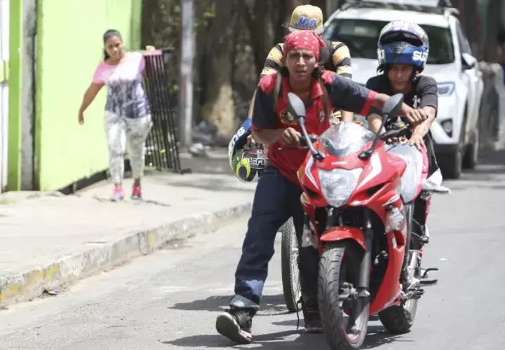 Los saqueadores se van con una motocicleta que acaban de sacar de una tienda en Managua. AP