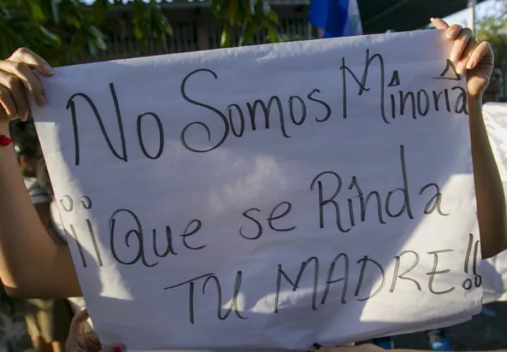 Varias jóvenes sostienen un cartel durante una gran manifestación contra el Gobierno. EFE