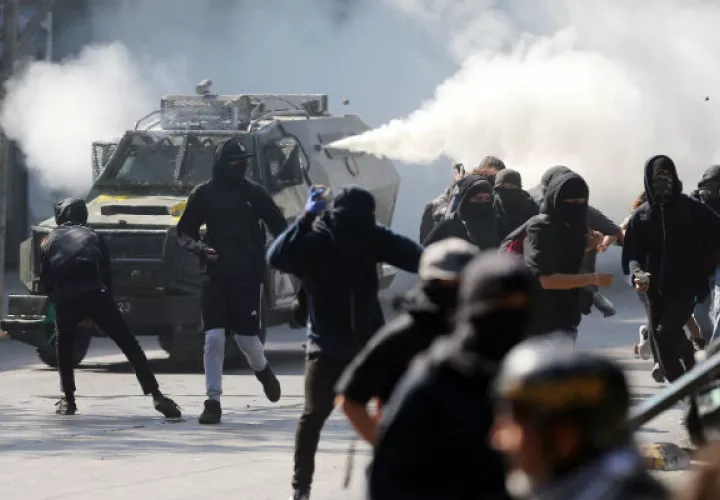 Los atimotines combaten a un grupo de estudiantes chilenos. FOTO/EFE