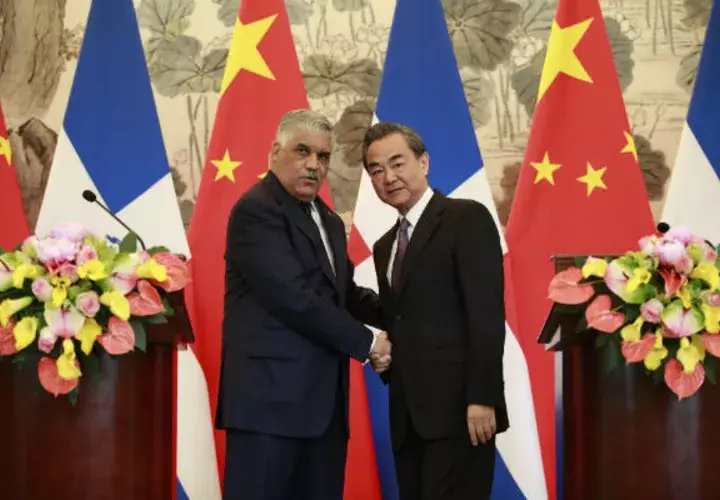 El ministro dominicano de Relaciones Exteriores, Miguel Vargas (i), y su homólogo chino, Wang Yi, se dan la mano después de una ceremonia de firma donde formalmente establecieron relaciones diplomática