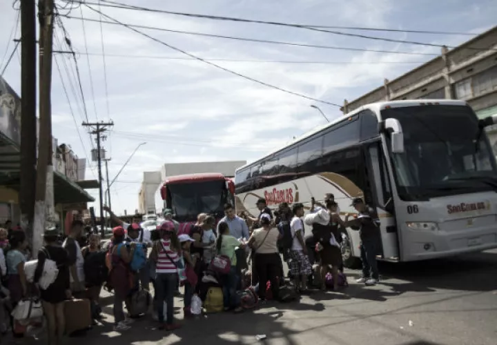 Miembros de la caravana de migrantes viajan en autobuses. FOTO/AP